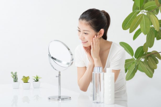 鏡の前で化粧する女性